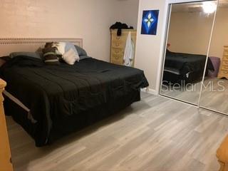 Bedroom with king-sized bed and wood floor.