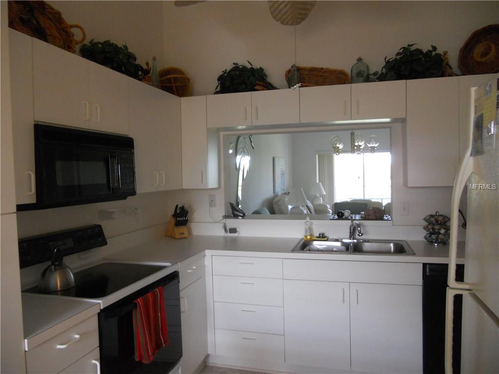 White kitchen with black appliances and window.