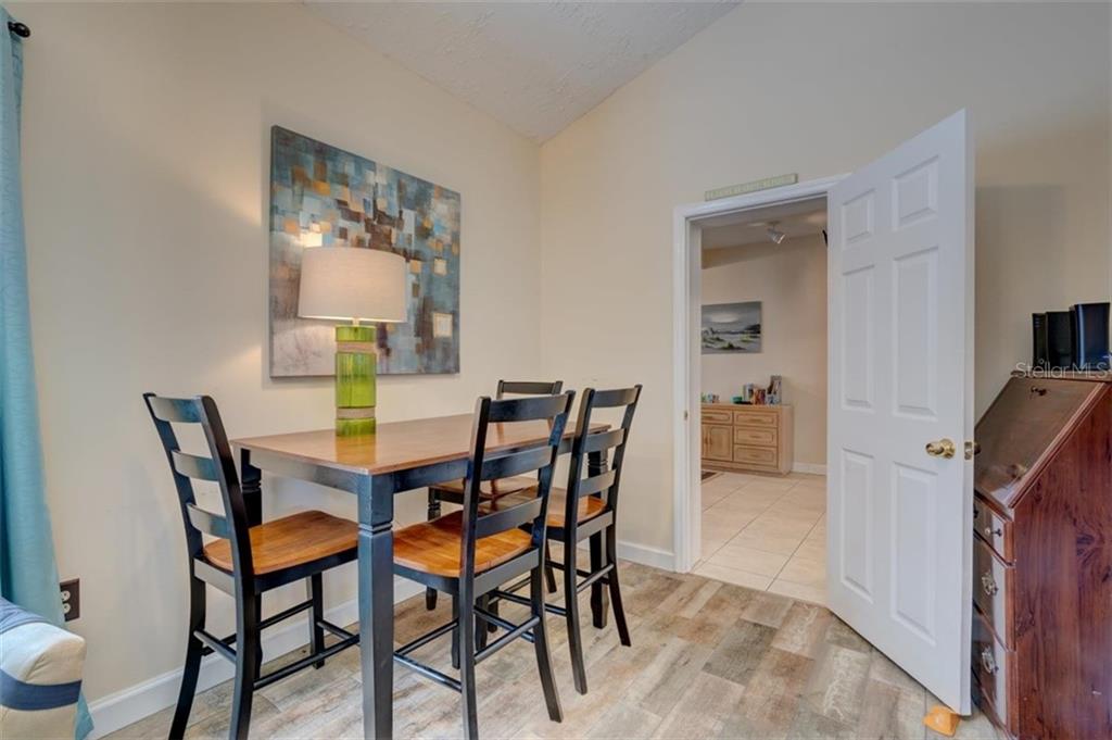 Dining room with table, chairs, and lamp.