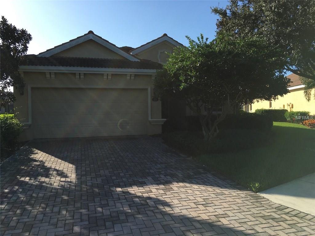 Brick driveway in front of house with garage.