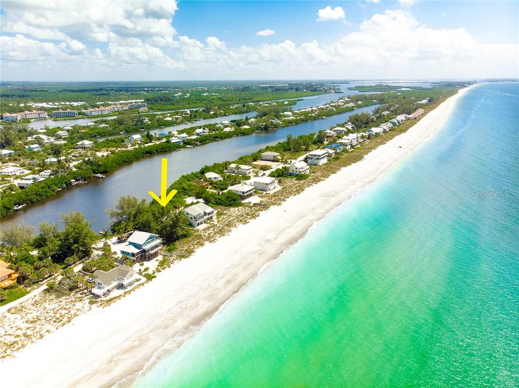 Aerial view of beach house by the water.