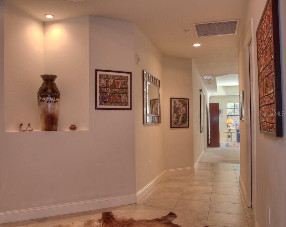 Hallway with tiled floor and artwork.