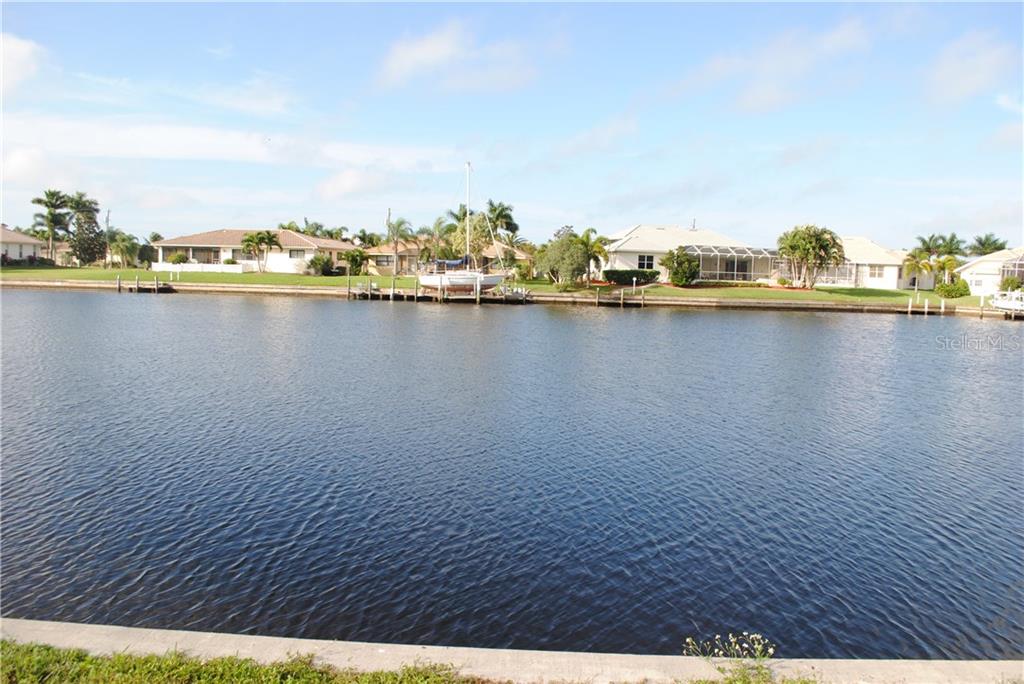 Calm water canal with houses in the background.