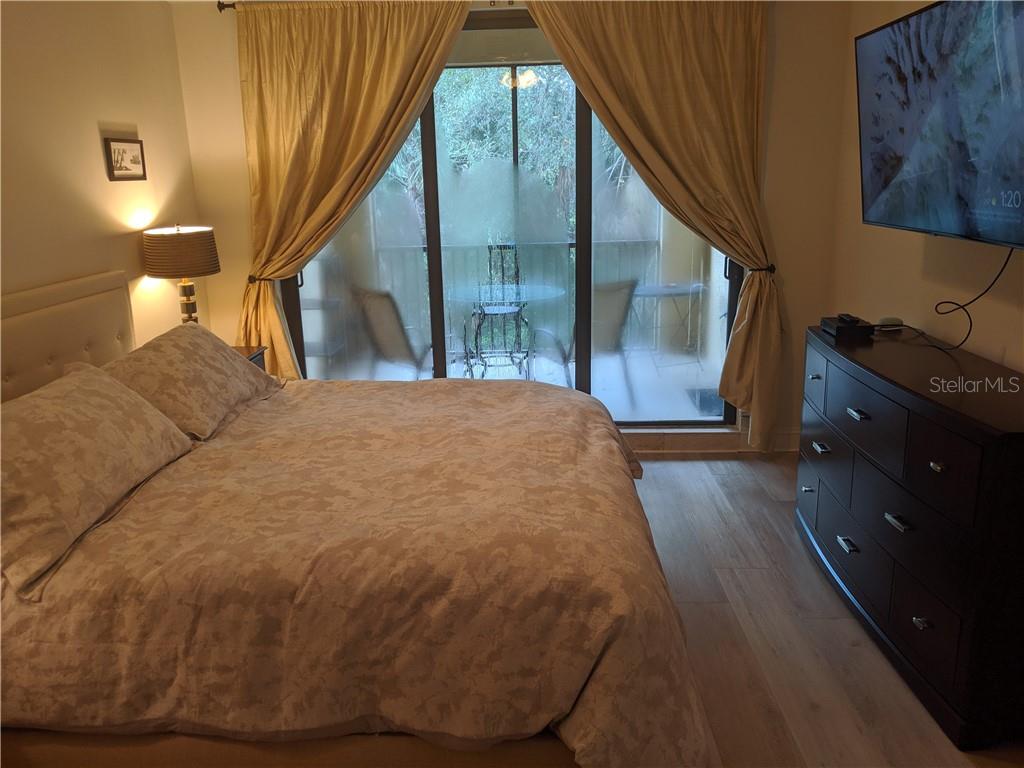 Bedroom with bed, dresser, and patio view.