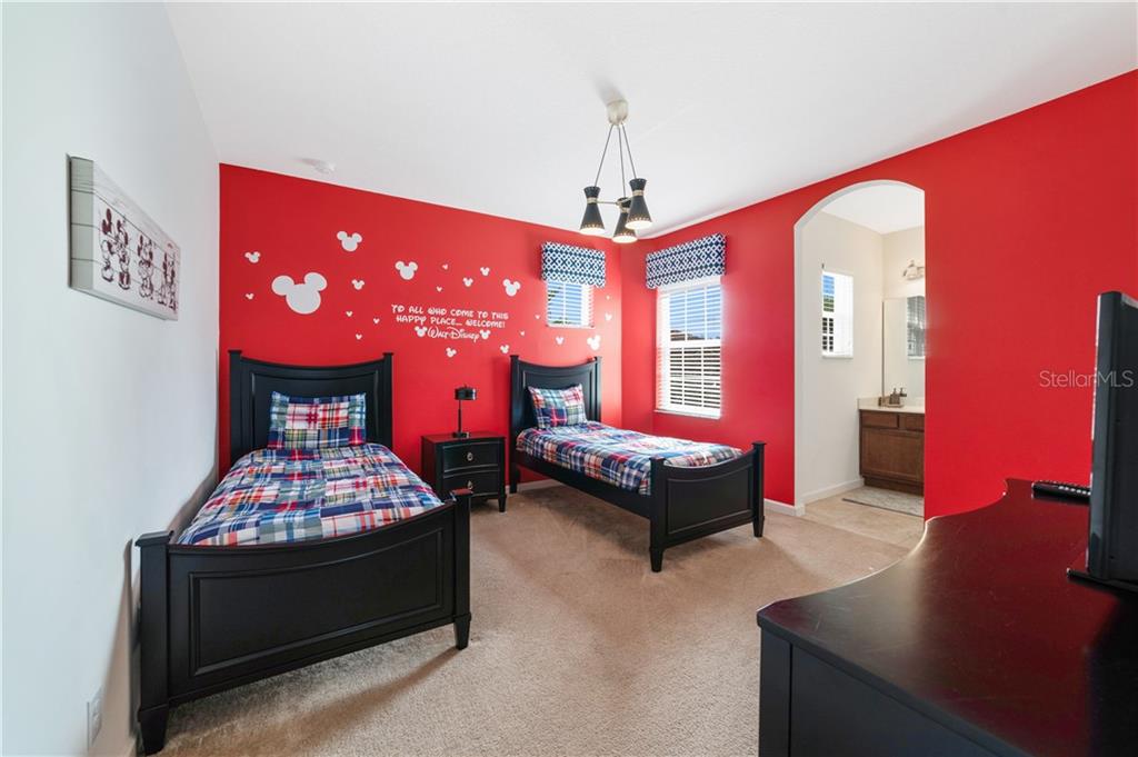 Red bedroom with two twin beds and Mickey Mouse decor.