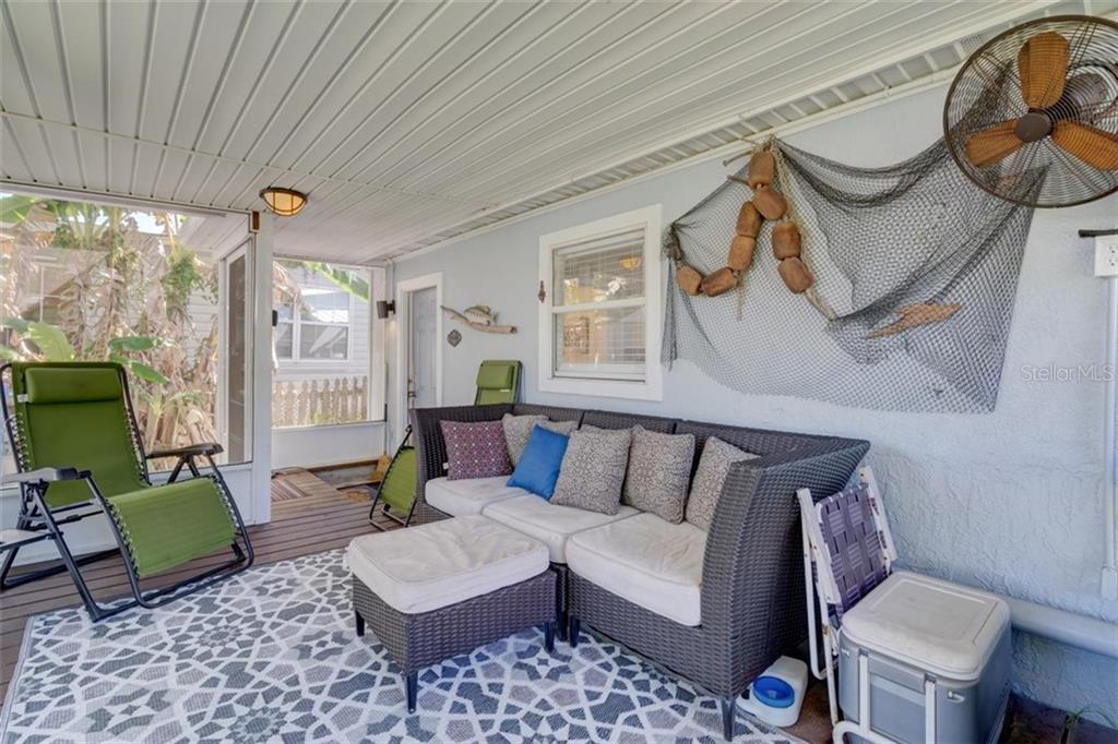 Outdoor patio with furniture and a fan.