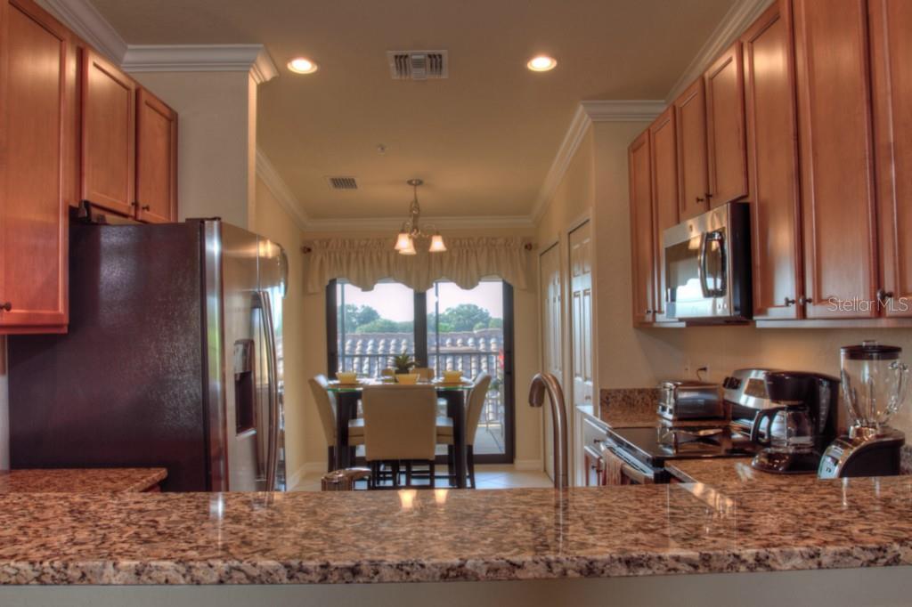 Modern kitchen with granite countertops and patio view.