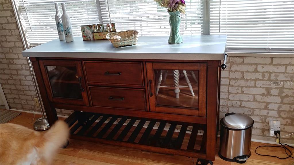 Wooden kitchen cart with drawers and shelves.