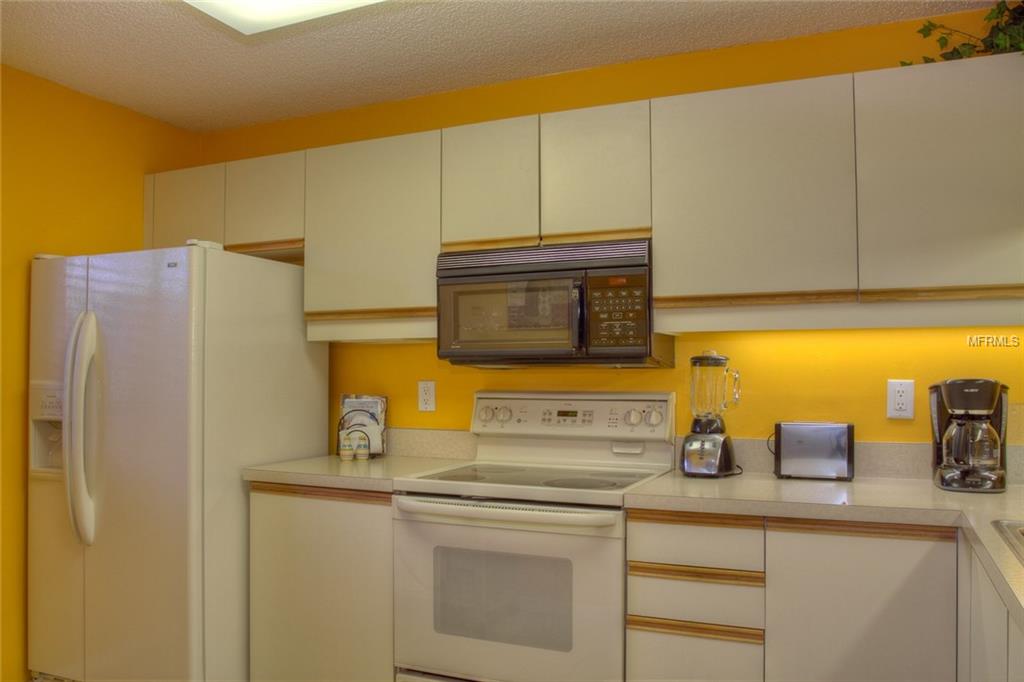 White kitchen with yellow walls and appliances.