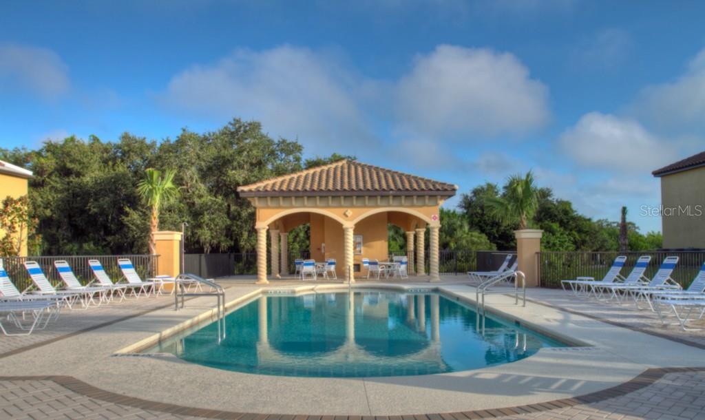 Swimming pool with lounge chairs and a gazebo.