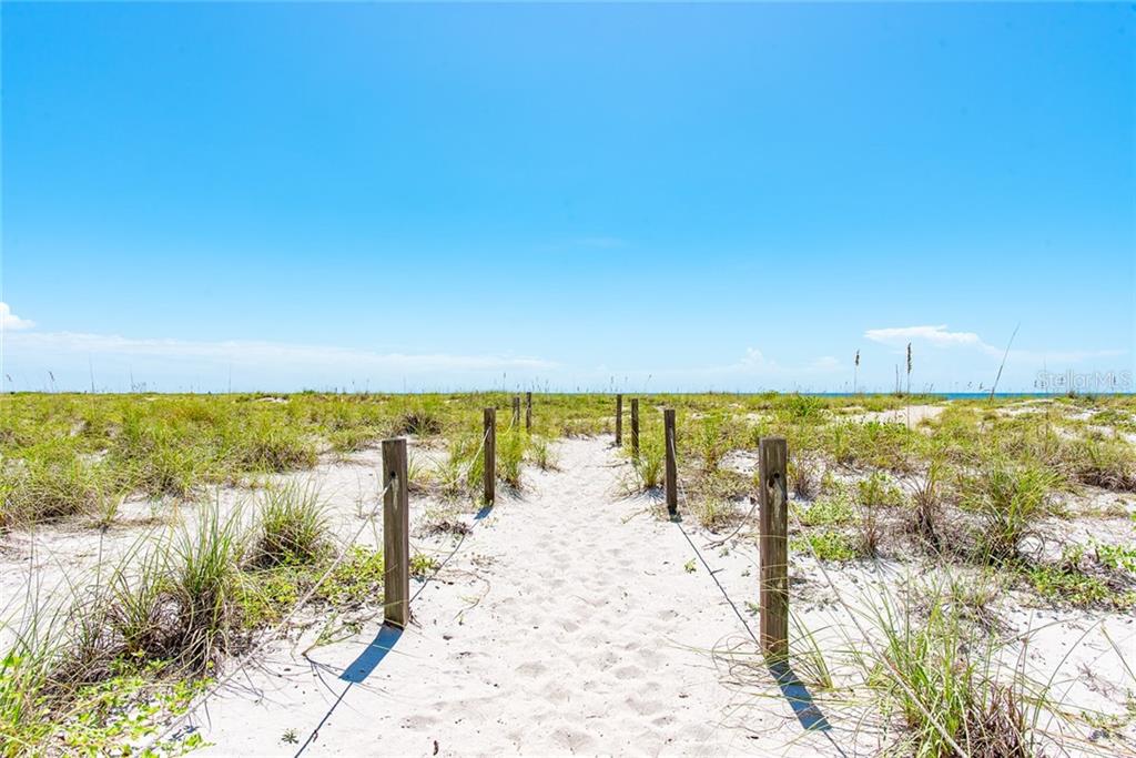 Sandy path to the beach with posts.