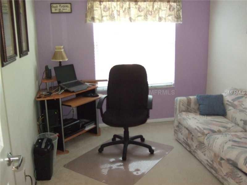 Home office with desk, chair, and couch.