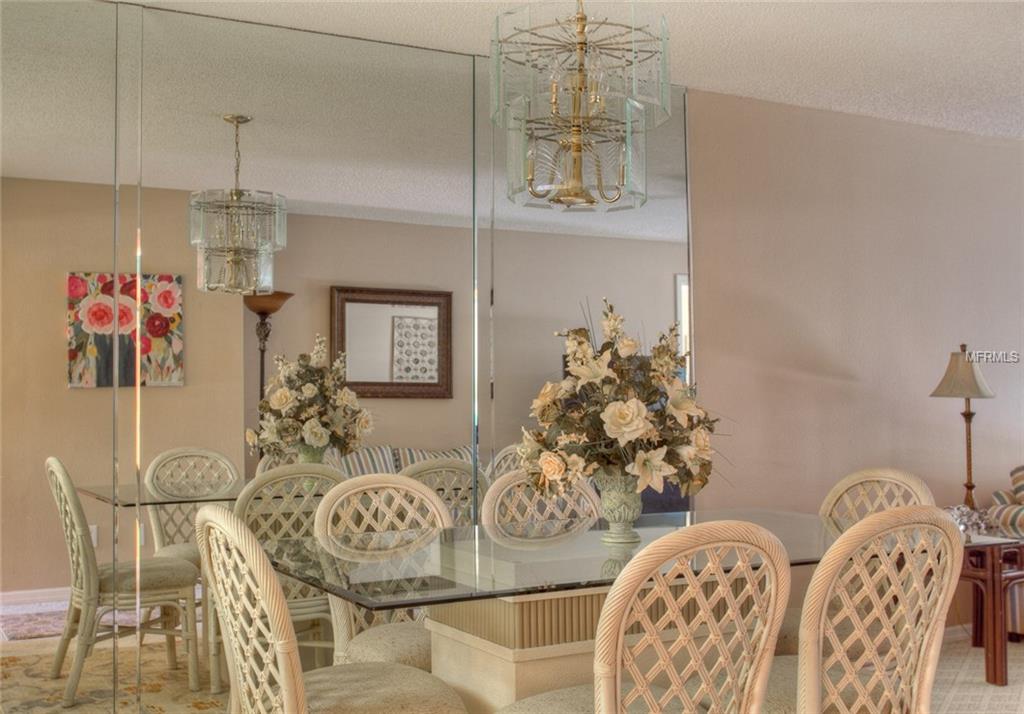 White wicker dining chairs with a glass table.