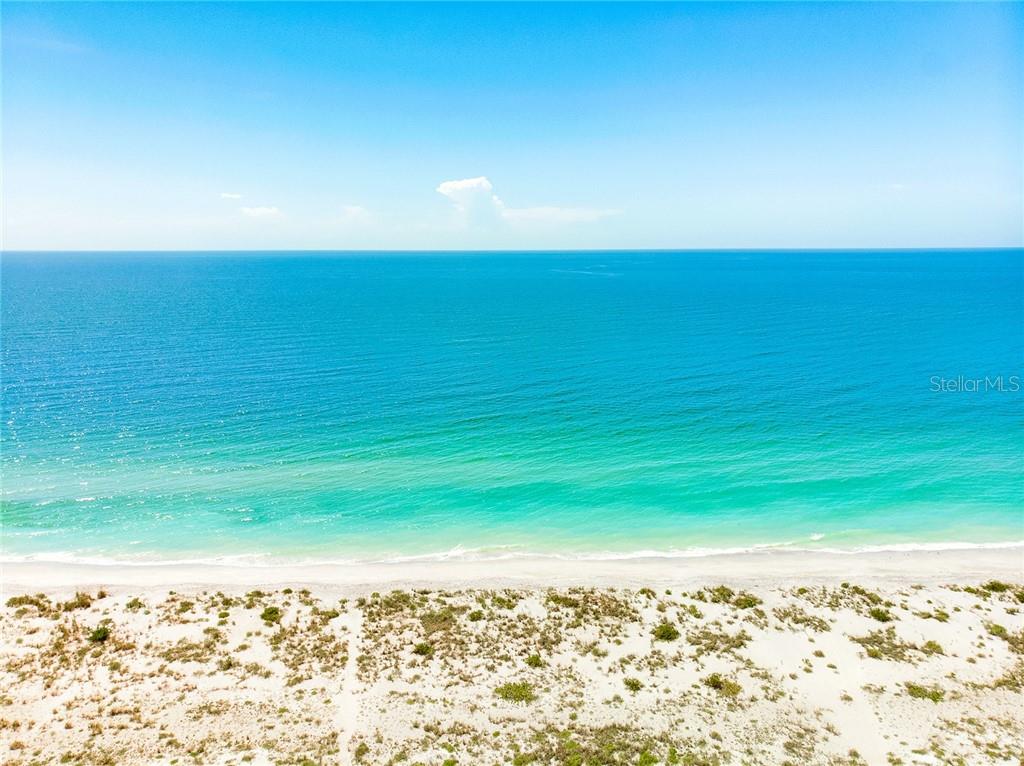 Aerial view of a sandy beach and blue ocean.