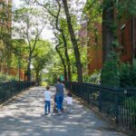 Family walking down a tree-lined street.