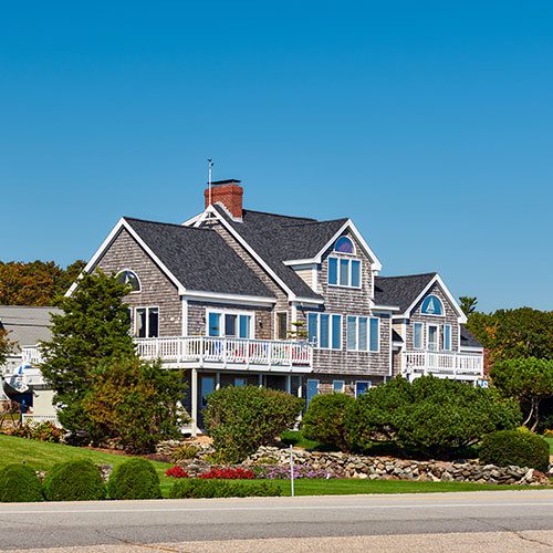 Two-story house with a deck and landscaping.