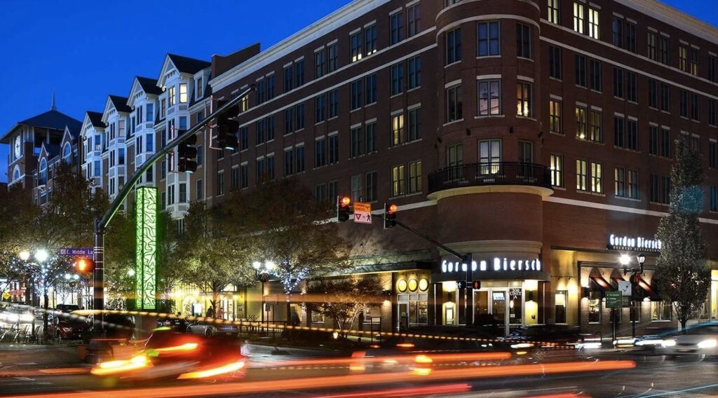 Nighttime view of a city street with a restaurant.