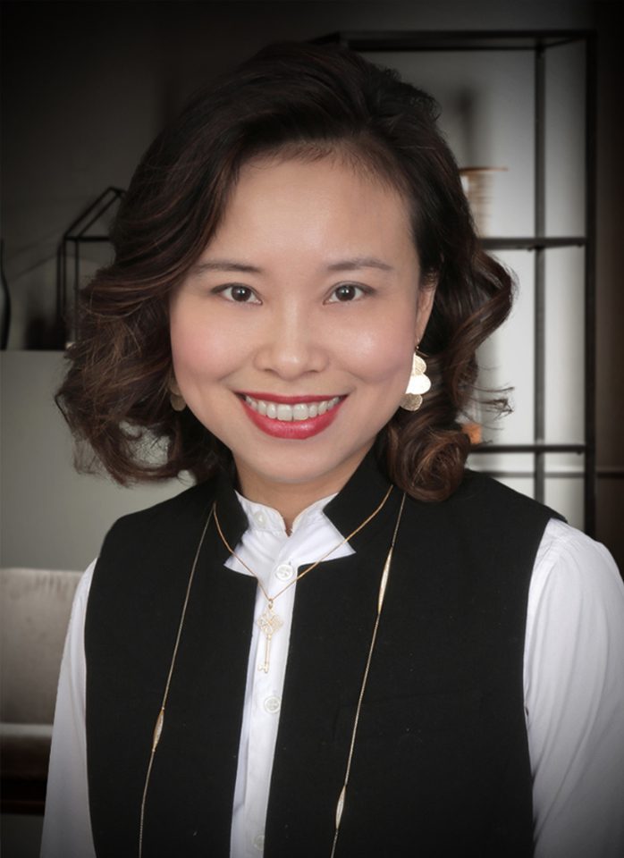 Smiling woman wearing a black vest.