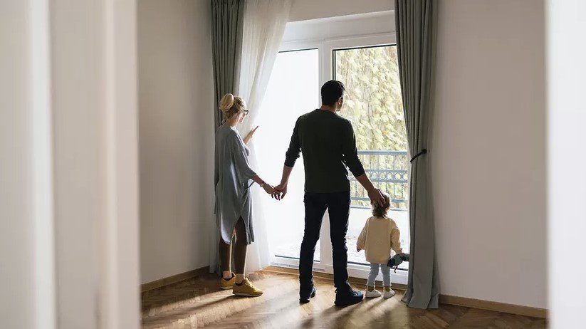 Family looking out a window in a new home.