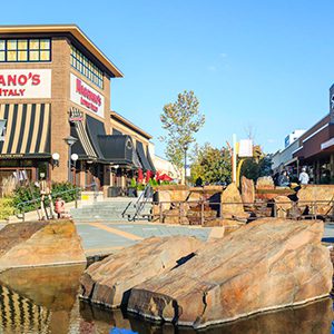 A fountain in front of a shopping center.