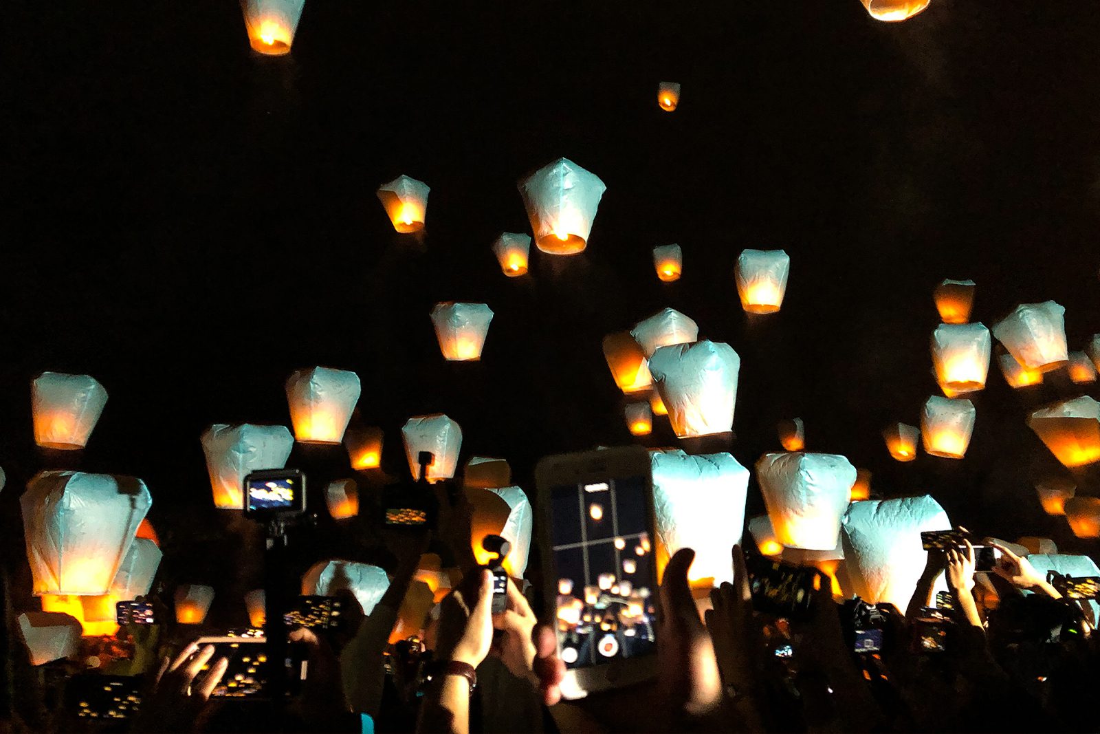 People releasing lanterns into the night sky.