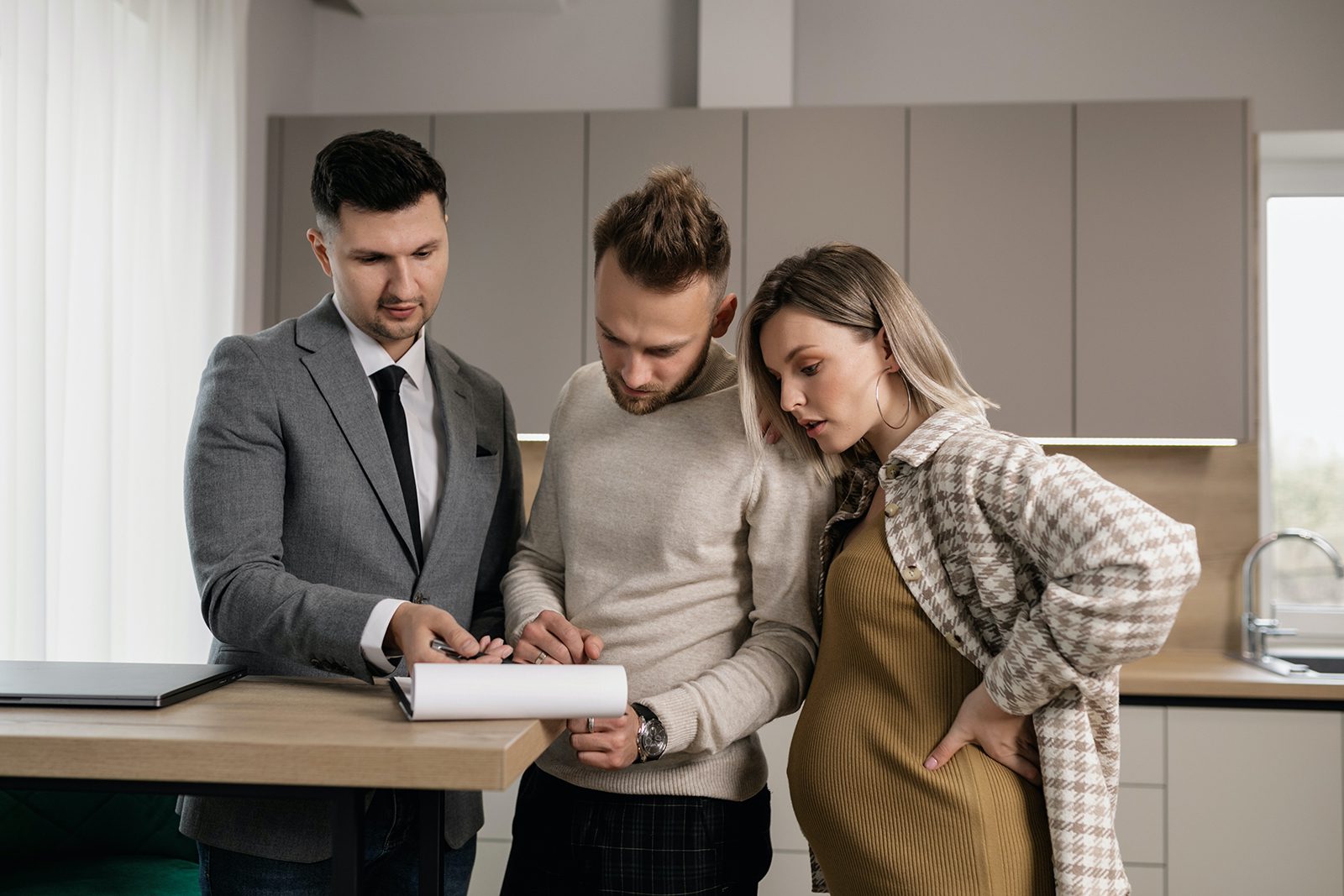 Couple signing papers with realtor.