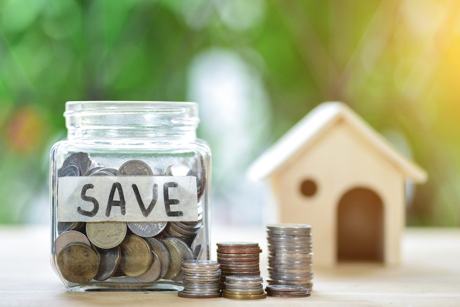 Coin jar labeled "save" with house model.