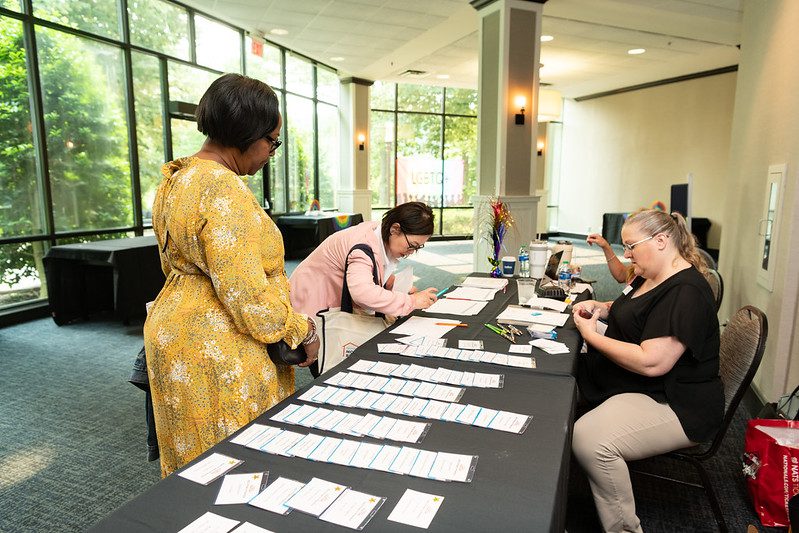Three women signing in at a conference.