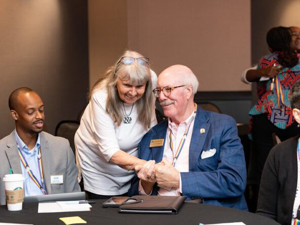 Two men and two women at a conference.