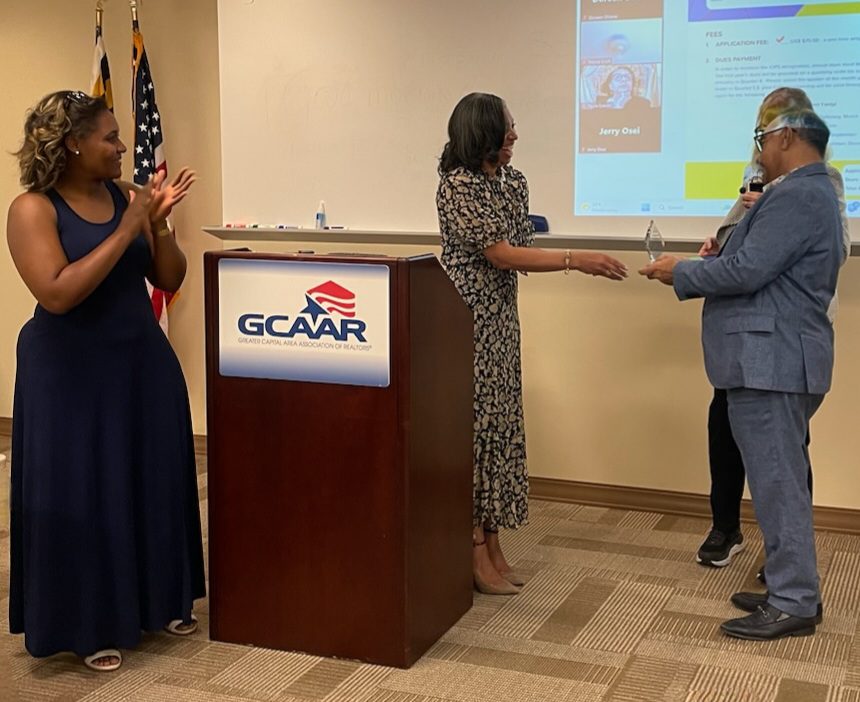 Award ceremony with three people and a podium.