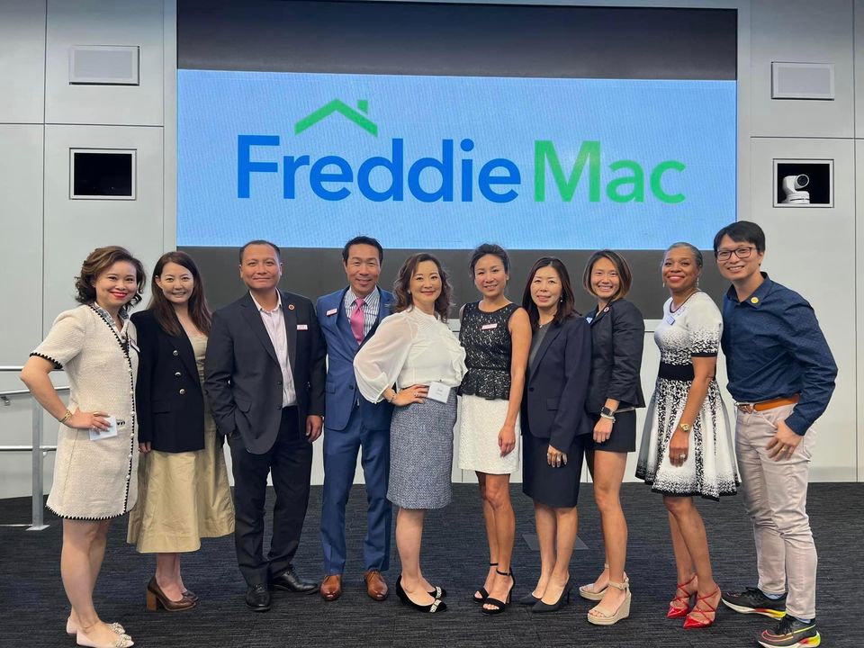 Group of people in front of Freddie Mac logo.