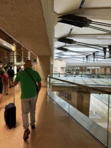 Man with luggage walking through airport terminal.