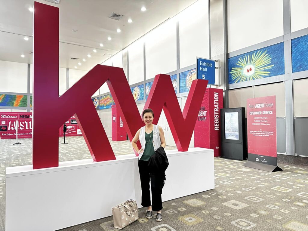 Woman standing in front of KW logo.