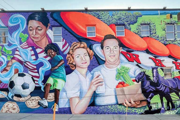 Colorful mural with diverse figures on a brick wall.