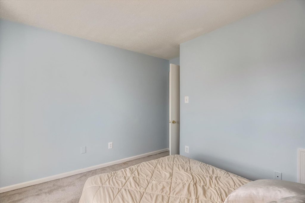 Minimalist bedroom with light blue walls.