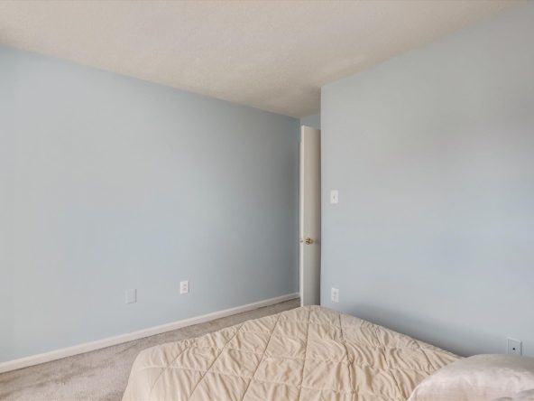 Minimalist bedroom with light blue walls.