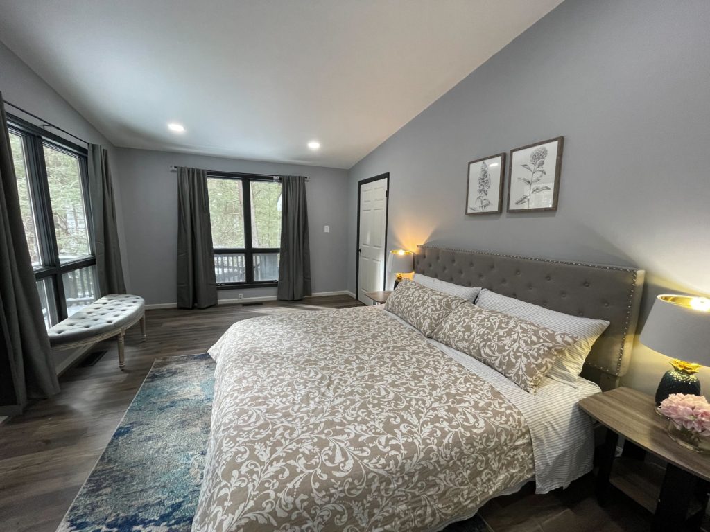 Modern bedroom with large bed and windows.