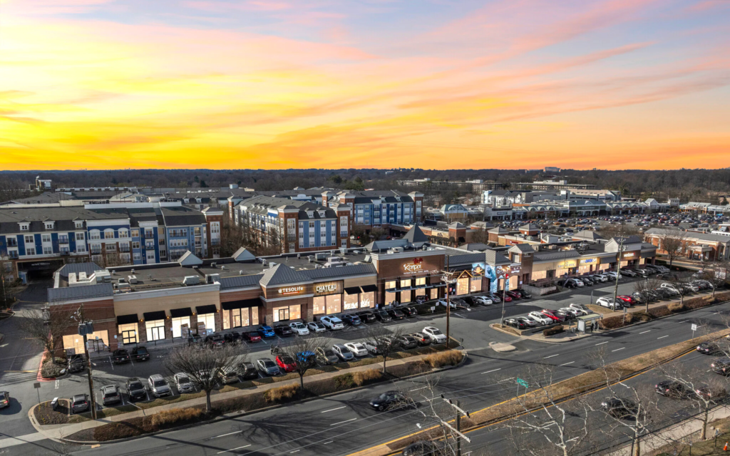Shopping center at sunset with parking lot.