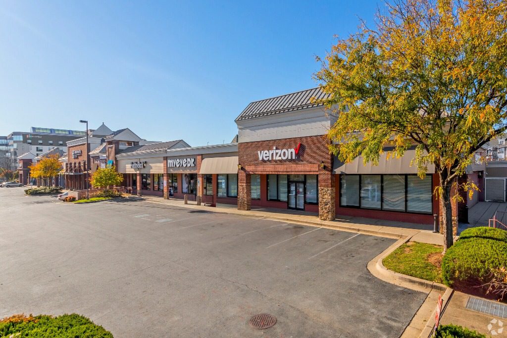 Empty shopping center parking lot, sunny day.